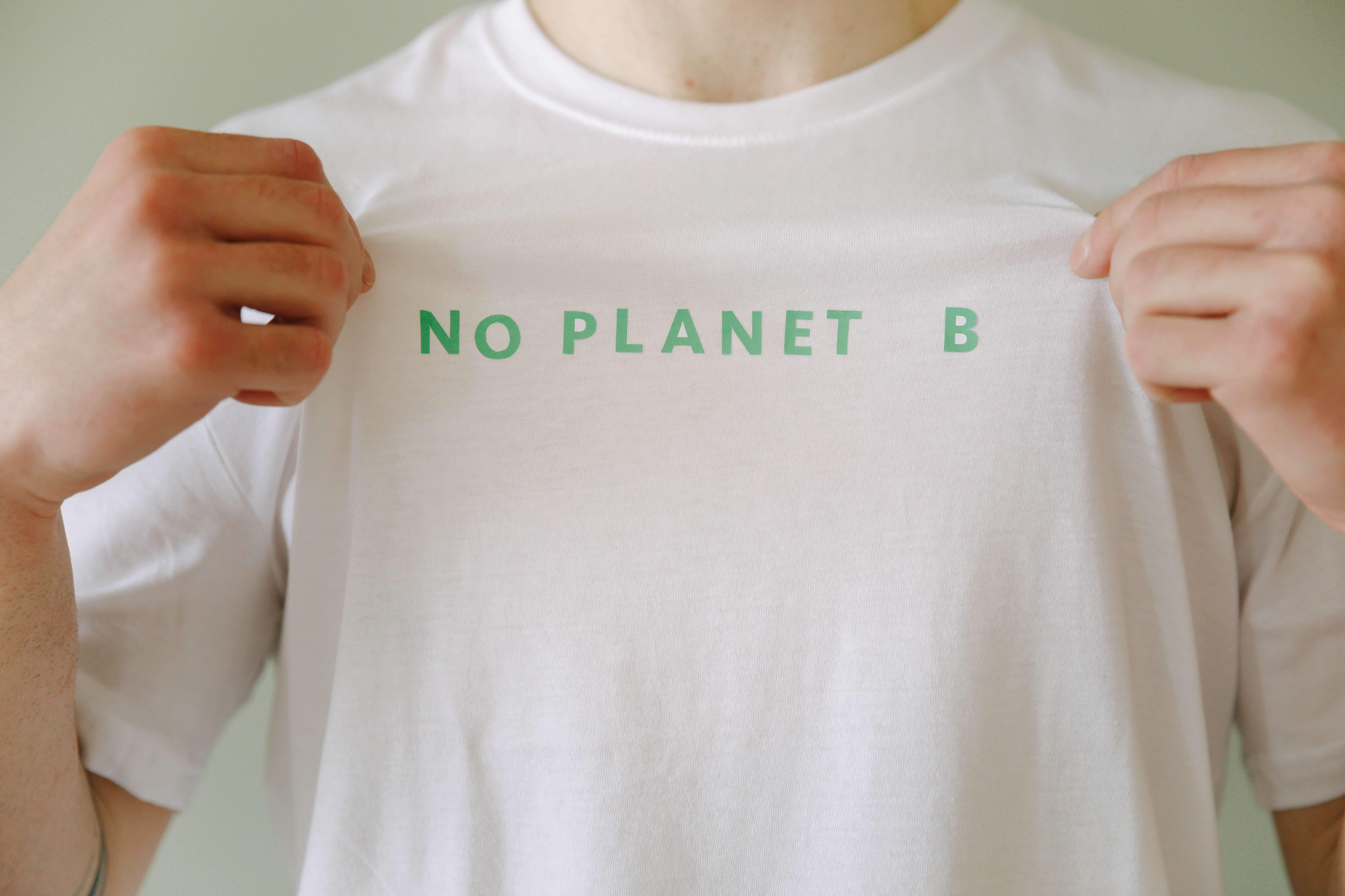 Mann zieht T-Shirt auseinander, um den Schriftzug 'No Planet B' sichtbar zu machen - Blogbeitrag 'Nachhaltigkeit im Norden: Dein ultimativer Guide mit Regizon