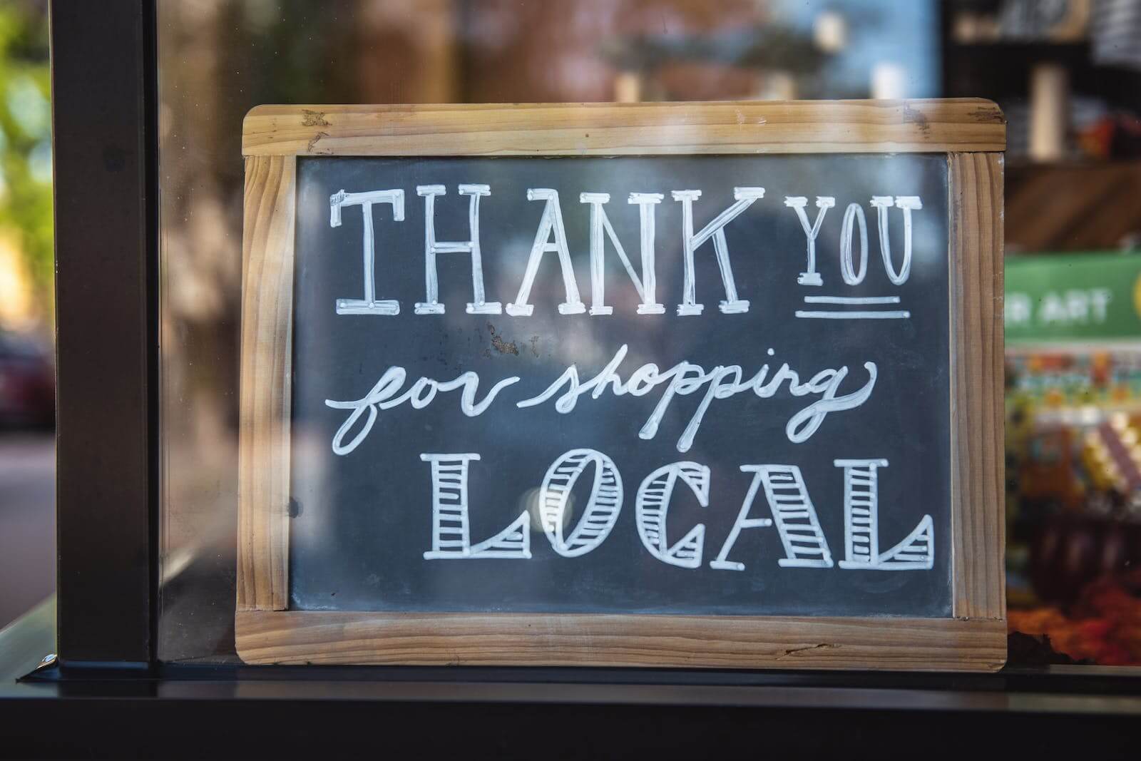 Ladenschild mit der Aufschrift 'Thank you for shopping local', symbolisiert die Wertschätzung für den lokalen Handel.